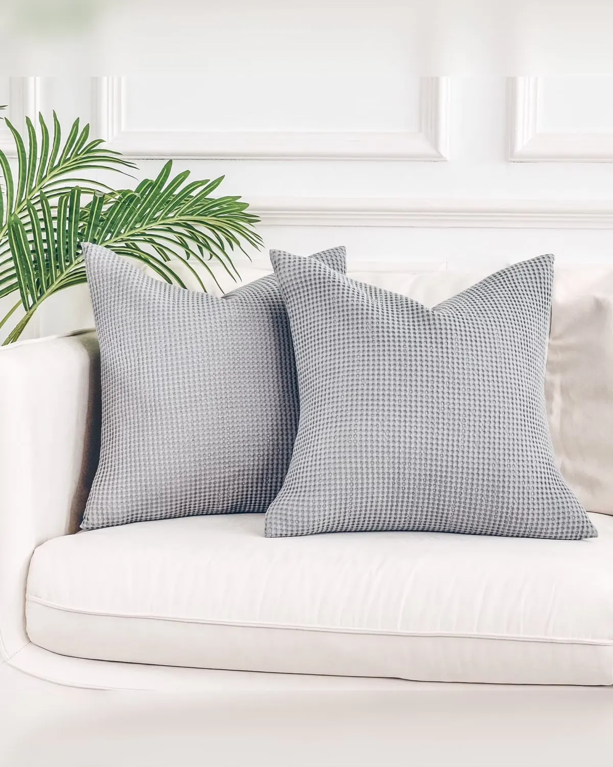 Two grey cotton waffle-weave throw pillow covers on a couch