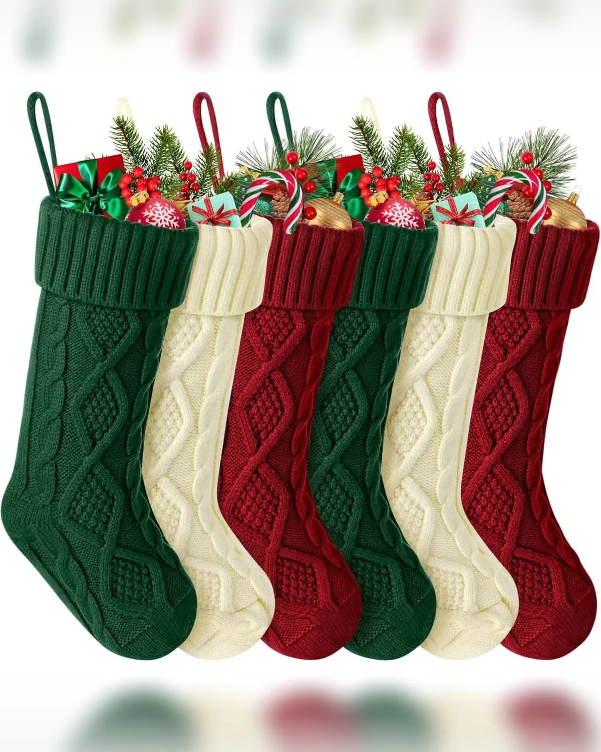 Set of knitted red, green and cream Christmas stockings hanging in a row