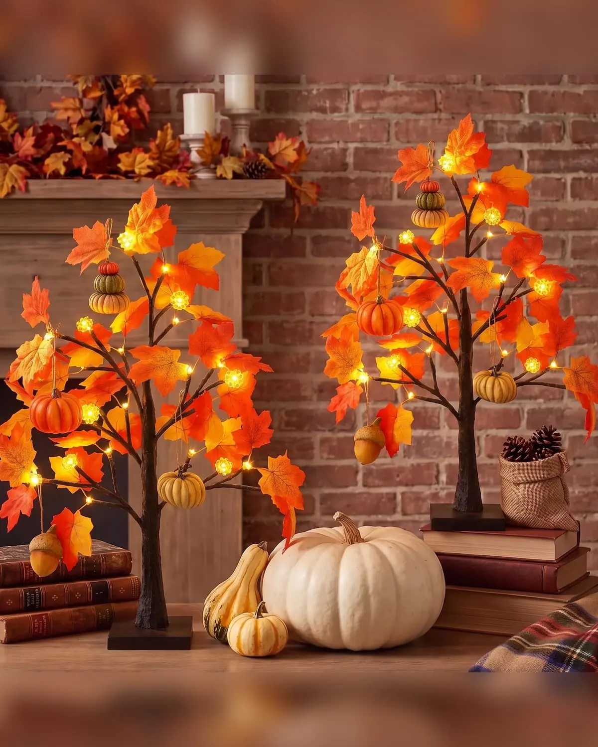 Two small lighted artificial fall maple trees with pumpkin ornaments