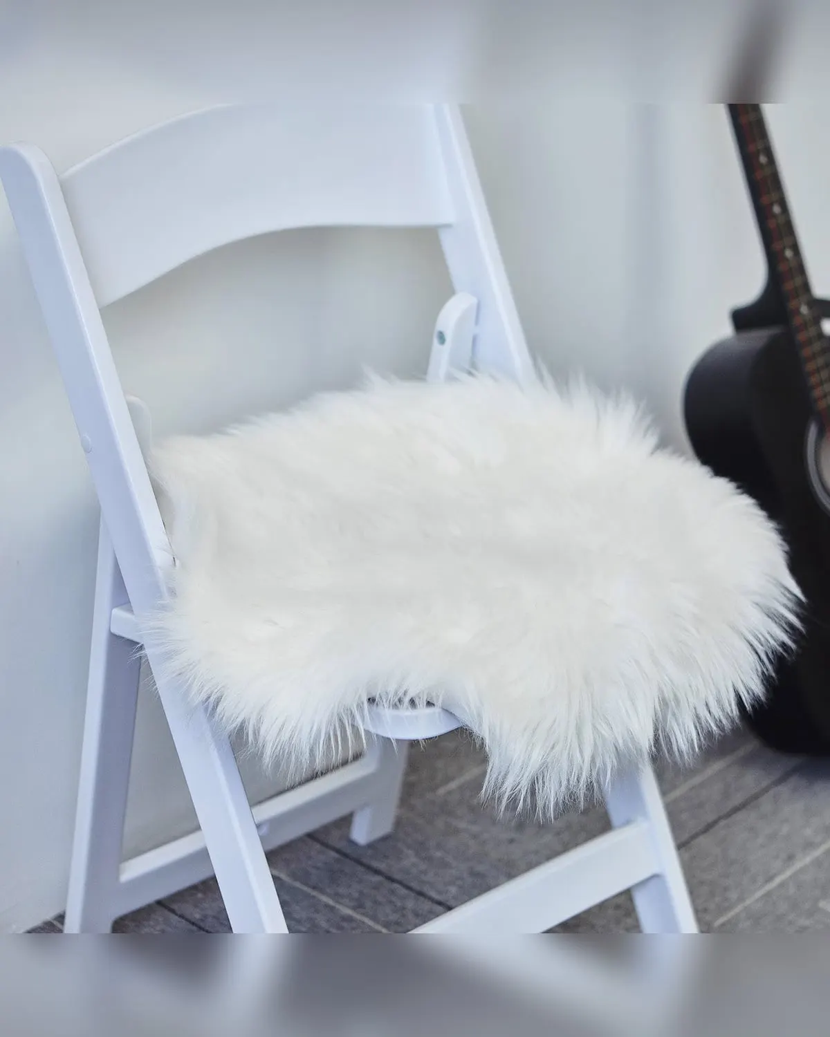 White faux sheepskin pad softening the seat of a hard folding chair