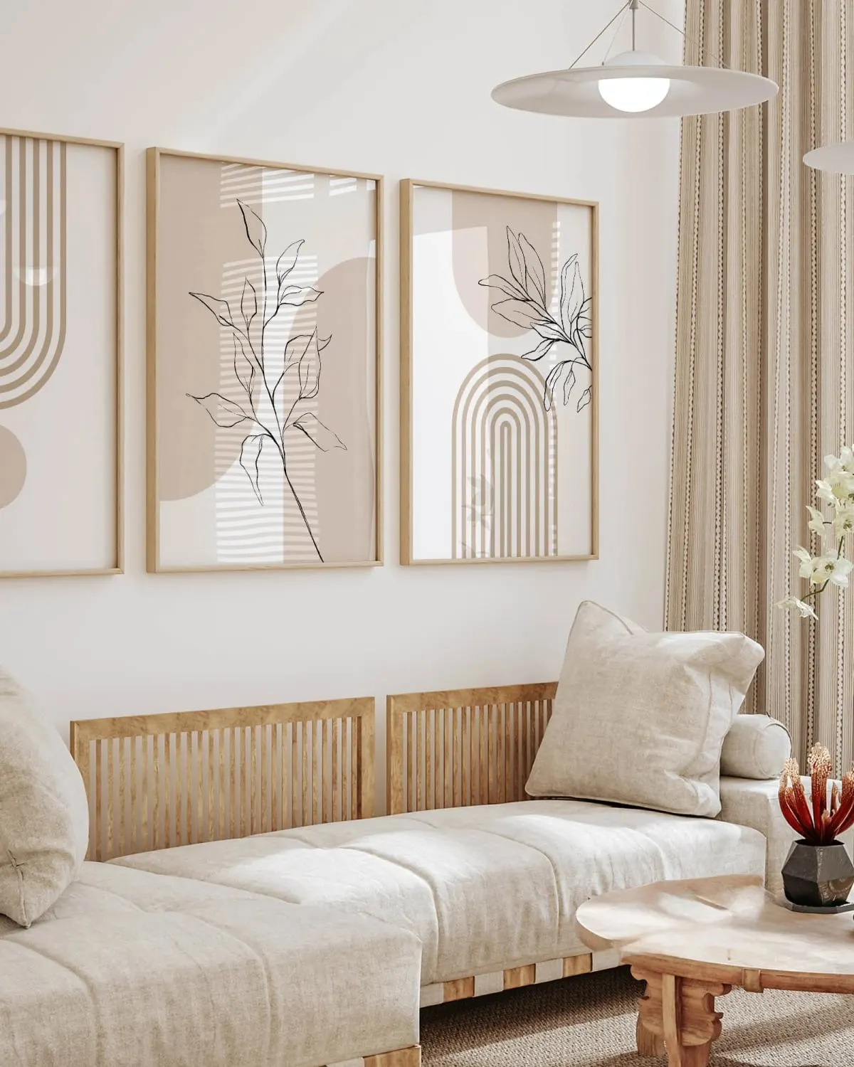 Set of three neutral beige botanical wall art prints above a sofa