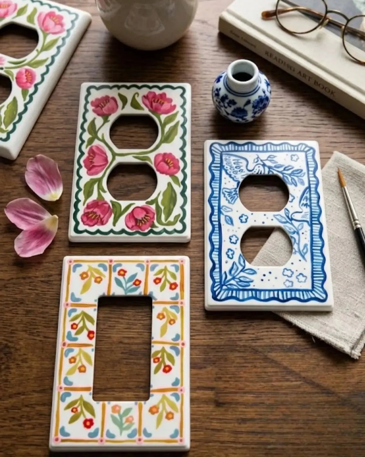 Hand-painted floral light switch cover on a wall